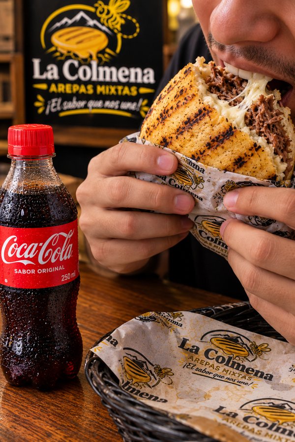 Persona disfrutando una arepa mixta La Colmena